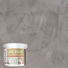 a can of paint sitting on top of a white table next to a gray wall