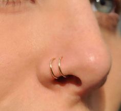 a close up of a person's nose with a gold nose ring on it