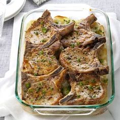 a casserole dish filled with meat and vegetables on top of a white table cloth