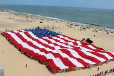 an american flag is being held up on the beach