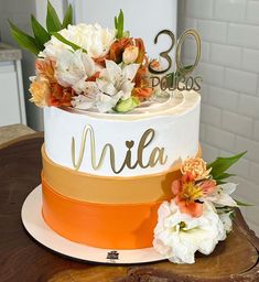 a white and orange cake sitting on top of a wooden table