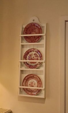 three plates in a shelf on the wall