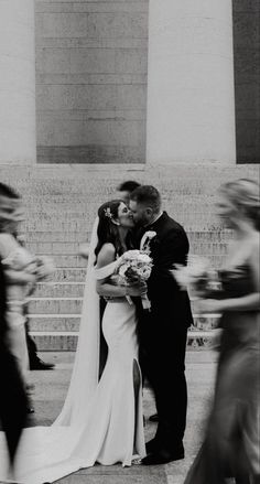 a bride and groom kissing in front of the lincoln memorial during their wedding day ceremony