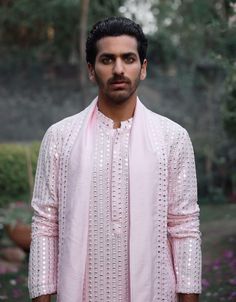 The jalalgarh kurta in powder pink is a charming and sophisticated choice for Indian grooms, ideal for haldi, mehndi, or sangeet ceremonies. Crafted from a luxurious blend of viscose cotton silk and georgette, this kurta offers a smooth and breathable feel, perfect for long celebrations. The kurta comes with an ivory salwar, creating a balanced and harmonious ensemble. The jalalgarh kurta is perfect for grooms who want a contemporary yet traditional outfit. Pair it with traditional juttis or modern footwear for a polished and sophisticated appearance. Pink Anarkali Cotton Silk Kurta, Bollywood Style Pink Cutdana Kurta, Pink Cutdana Bollywood Kurta, Bollywood Style Pink Cotton Silk Kurta, Pink Cotton Silk Kurta With Resham Embroidery, Pink Resham Embroidery Cotton Silk Kurta, Pink Bandhgala With Dabka Work, Pink Long Sleeve Sherwani With Dabka Work, Pink Sherwani With Dabka Work For Eid