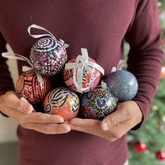 a person holding some ornaments in their hands