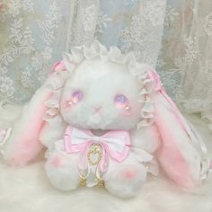 a white stuffed rabbit with pink ears and eyes