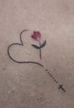 a small heart with a rose on it and a cross drawn in the middle by someone's hand