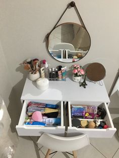 a white vanity with two drawers and a mirror on the wall next to it,