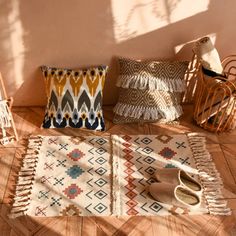 a pair of slippers sitting on top of a wooden floor next to pillows and rugs