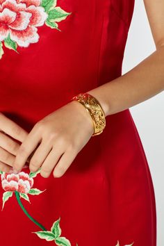 Rock the dragon and phoenix symbol in a more subtle way with this gold bangle. We recommend pairing it with our qun kwa dresses or our Ali dress. This bangle run a bit smaller (20cm circumference). Please check your wrist measurements. **Check out additional dresses at www.eastmeetsdress.com.** The Details: - Single bracelet - Dragon and phoenix detailing with double happiness symbol - Dimensions: 20cm x 2 cm - Finish: 23k gold plated - Closure: Box clasp Timeline: Our products are made to order Gold Jewelry With Dragon Design, Gold Round Jewelry With Dragon Design, Gold Dragon Design Jewelry, Traditional Gold Jewelry With Dragon Design, Elegant Adjustable Dragon Design Jewelry, Elegant Adjustable Jewelry With Dragon Design, Phoenix Bracelet, Qun Kwa, Double Happiness Symbol