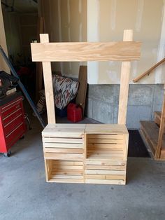 a wooden bench sitting in the middle of a garage next to a red toolbox