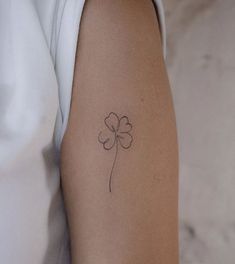 a four leaf clover tattoo on the arm