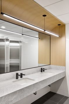 a public restroom with two sinks and mirrors