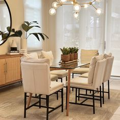 a dining room table with six chairs and a potted plant in the center area