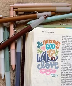 an open bible next to pens and markers