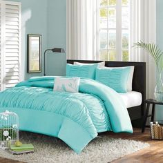 a bed with blue comforters and pillows in a room