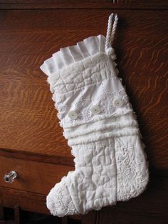 a white christmas stocking hanging from a wooden dresser