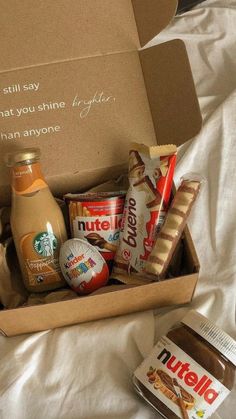 an open nutella box on a bed next to some other food and condiments