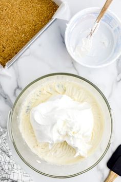 the ingredients to make this cake are in bowls and on the counter top, including whipped cream