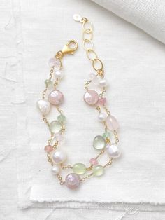 This luxe layered bracelet boasts a lavish combination of pink and green gemstones and freshwater pearls, creating a refined and feminine design. Lobster clasp and extender chain allow for an adjustable fit. Bracelet length:  7.5-8.5 inches Materials:  gold fill, rose quartz, prehnite, tourmaline, mystic moonstone, green amethyst, cultured freshwater pearls GIFTING ~ Jewelry gift box included. ~ I am happy to ship directly to the recipient.  Enter their address during checkout. ~ If you would like a gift note included in the package, please leave the text of the note in the "Add a note to Marsh Creek Jewelry" message box at checkout. FREE SHIPPING ~ Orders ship within 2 business days. ~ Free shipping is First Class ~ Priority Mail and Express Shipping upgrades are available during checkout Elegant Double Strand Beaded Bracelets With Faceted Beads, Elegant Multi-strand Gemstone Beaded Bracelets, Elegant Double Strand Bracelet With Faceted Beads, Elegant Double Strand Faceted Beaded Bracelets, Elegant Double Strand Bracelets With Gemstone Beads, Elegant Double Strand Gemstone Beads Bracelets, Elegant Double Strand Natural Stones Bracelets, Elegant Pink Bracelets With Natural Stones, Keshi Pearl Bracelet