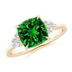 a green diamond ring with three diamonds on the band and an emerald colored stone in the center