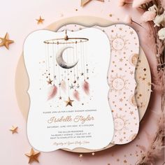 a pink and gold baby shower with stars, moon and crescent hanging from the ceiling