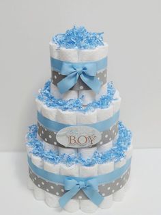 a three tiered diaper cake with blue and gray decorations