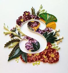 the letter s is made out of paper and has many flowers on top of it