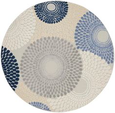 a round rug with blue and white circles on it's center, in front of a