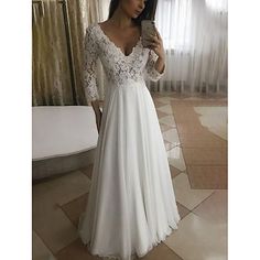 a woman is taking a selfie in her wedding dress while wearing a white lace and chiffon gown