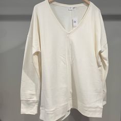 New W Tags, Never Worn, Gap V-Neck Sweatshirt, Off White Color, Large And Loose Fitting. A Seam Runs Along The Bottom, Along The Cuffs, And Down The Middle Of The Front And Back To Add Dimension. Relaxed Fit Cotton V-neck Top For Loungewear, Cotton Relaxed Fit V-neck Top For Loungewear, White Cotton V-neck Top For Everyday, Spring V-neck Sweatshirt For Loungewear, Casual Cream V-neck Top, Gap Everyday Fall Tops, Gap Everyday Tops For Fall, Gap Tops For Everyday Fall Wear, White Relaxed Fit V-neck Top