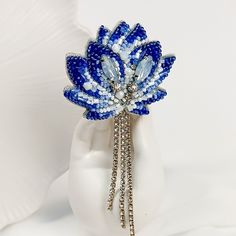 A chic handmade jewelry brooch with a blue lotus. Сrystal jewelry blue flower brooch will perfectly complement your unique jewelry collection. If you are looking for something blue, this is exactly what you need. With this handmade jewelry, you will be unique and individual. The autumn brooch has always been a fashionable and stylish accessory. The brooch can be worn not only on a dress or t-shirt, but also on outerwear, on a headdress and even on a backpack or bag and shoes, wherever your fanta Blue Crystal Brooches For Gifts, Bag And Shoes, Blue Lotus Flower, Embroidered Brooch, Brooch Diy, Brooch Handmade, Blue Tulips, Flower Crystal, Jewelry Brooch