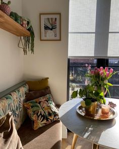 a living room with a couch, coffee table and flowers in the vase on top