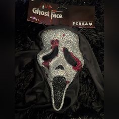 a creepy mask with red eyes and black hair on top of a fur covered floor