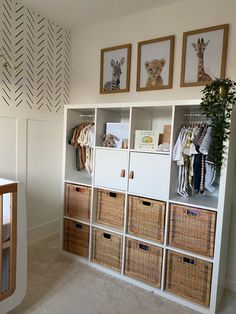 a baby's room with several baskets and pictures on the wall