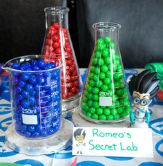 two vases filled with different colored balls on top of a table