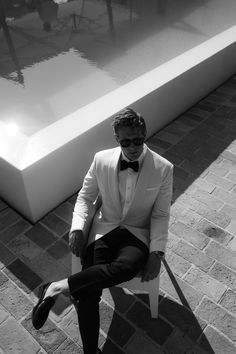 a man in a tuxedo sitting on a bench