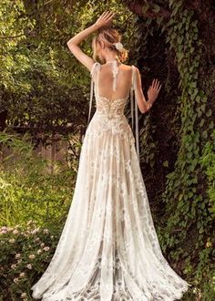 the back of a woman's wedding dress, with her hands on her head