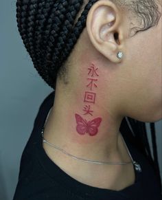 a woman with a tattoo on her neck and behind her ear is a pink butterfly