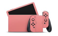 two nintendo wii game controllers sitting side by side on top of each other, one pink and the other black