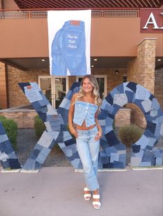 a woman standing in front of a sign that says ok with an image of a blue jean jacket on it