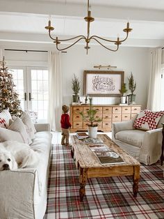 a living room filled with furniture and a christmas tree on top of a coffee table