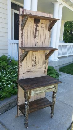 an old wooden shelf sitting on the side of a house