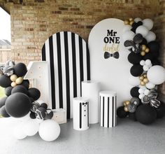 black and white balloons are on display in front of a sign that says mr one is about