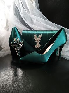 Elevate your evening ensemble with these exquisite Forest Green Satin Evening Shoes. Perfect for a Gothic Wedding, these stunning heels are a must-have for any bride or bridesmaid looking to make a statement. The carved detailing adds a touch of elegance, while the matching clutch bag ensures a coordinated and polished look for any formal event. Step out in style and grace with these luxurious heels and clutch set that are sure to turn heads and make you stand out from the crowd. Specifications: Luxurious Heels, Wedding Heels For Bride, Emerald Green Heels, Heels For Bride, Shoes Gothic, Shoes Board, Stunning Heels, Green Heels, Gothic Wedding