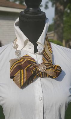 Designed with You in Mind" "TRACEY NECKTIE ESCARPE" This necktie is a redesign brown, yellow, and black elegant beauty. It speaks modest, class, and confidence.  It is a perfectly knotted delight. It's simple, but oh so elegant. It is complete with a rhinestones accented neckline. (Outfit not included) Necktie Necklace Diy, Tie Upcycle, Upcycle Ties, Neckline Outfit, Necktie Outfit, Old Neck Ties, Diy Necktie Projects, Upcycled Neckties, Alexandria Louisiana