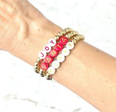 ❤️The listing is for one bracelet. Perfect for adding to a stack of wearing alone! Bracelets make a great gift!  ❤️Gold bracelet is made with 14k gold plated beads in 5mm. Choose from white letter beads with red, red letter beads with gold or pink letter beads with white and customize the word or type in a name!    ❤️Bracelet makes a perfect gift for the one you love!  XXS- 5.5 inches XS- 6.0 inches S- 6.5 inches M- 7.0 inches L- 7.5 inches ❤️Each bracelet is custom made so all sales are final and no refunds will be issued. Please check all size and personalization ( if needed) prior to ordering.  ❤️Tips: Do not get bracelets wet. They may tarnish. Please remove before showering or swimming.  Roll the bracelet onto your wrist instead of pulling or stretching it on. Do not leave in direct s Christmas Bracelets Beaded, Holiday Word, Word Bracelets, Bracelets Easy, Bracelet Inspo, Word Bracelet, Diy Bracelets Easy, Pink Letter, Christmas Bracelet