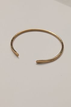 14k recycled gold-plated brass 14k gold-plated sterling silver ear posts Approximately 6" around wrist Nickel & lead free Crafted using responsibly sourced and recycled metals Handmade in a solar-powered workshop in rural Malawi The 'Mawoko' Bracelet (meaning 'Arm' in Tumbuka) is an essential addition to any jewelry collection. The bracelet features an adjustable, practical design to ensure the perfect fit for most wrists, while its hammered finish and smoothed teardrop ends create an elevated, Bracelet Meaning, Bracelets With Meaning, Jewelry Workshop, Recycled Jewelry, Practical Design, Recycled Gold, Gold Hoops, Solar Powered, Gold Studs