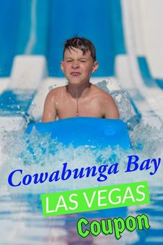 a young boy riding on top of a blue raft in the water at a water park