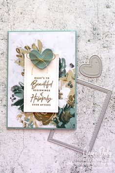 a handmade card with flowers and leaves on it, next to a pair of scissors